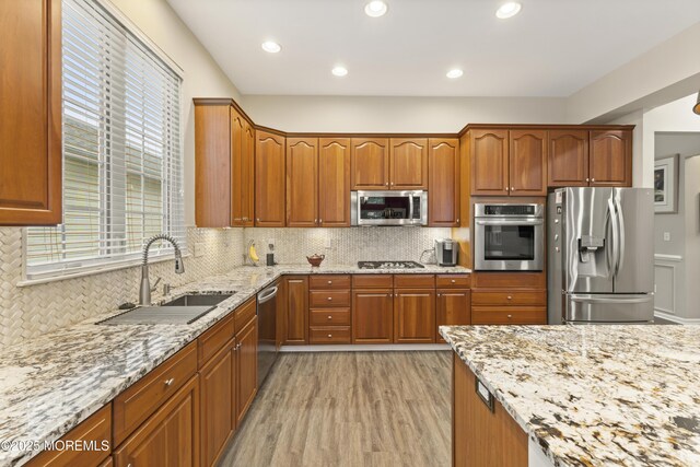 6 Beth Page Dr, Monroe, NJ 08831 - kitchen with appliances with stainless steel finishes, a sink, light stone countertops, light wood-style flooring, and brown cabinets