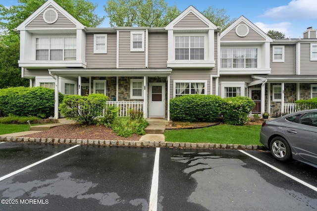 17 Canidae Ct, Tinton Falls, NJ 07753 - townhome / multi-family property featuring covered porch, stone siding, and uncovered parking