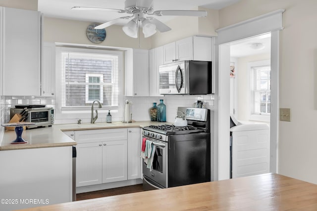 400 W Lake Ave, Bay Head, NJ 08742 - kitchen with stainless steel appliances, a sink, a ceiling fan, and tasteful backsplash