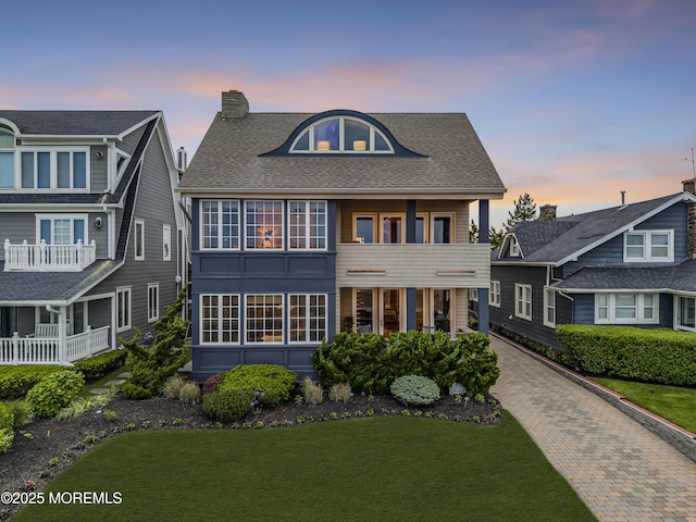 2009 Ocean Ave, Spring Lake, NJ 07762 - view of front of property featuring a balcony, a lawn, decorative driveway, a chimney, and roof with shingles
