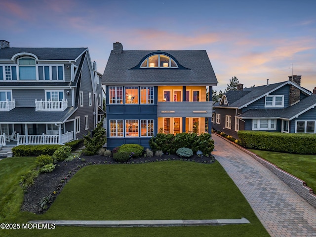 2009 Ocean Ave, Spring Lake, NJ 07762 - view of front facade featuring a front yard, a chimney, and decorative driveway
