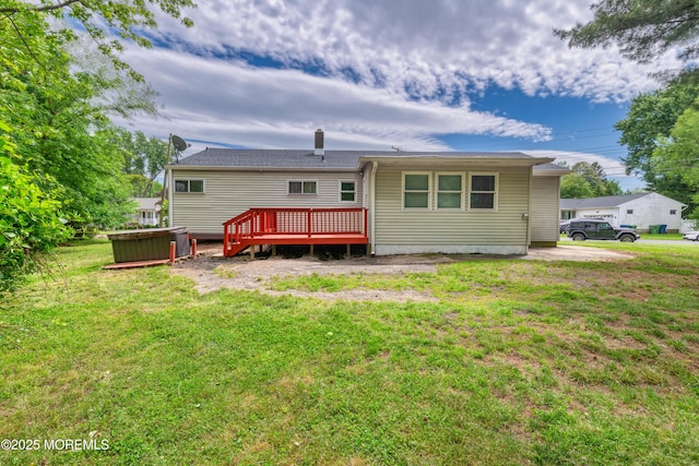 rear view of house with a deck and a yard