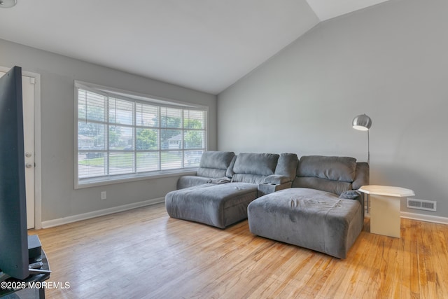 living room featuring vaulted ceiling, wood finished floors, and baseboards