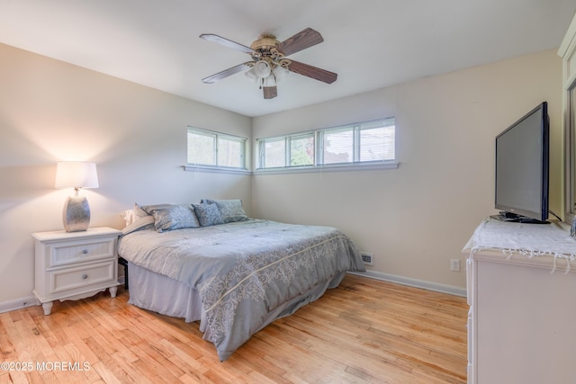 bedroom featuring light wood finished floors, baseboards, and a ceiling fan