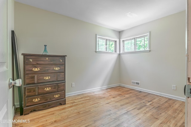 unfurnished bedroom with light wood-type flooring and baseboards