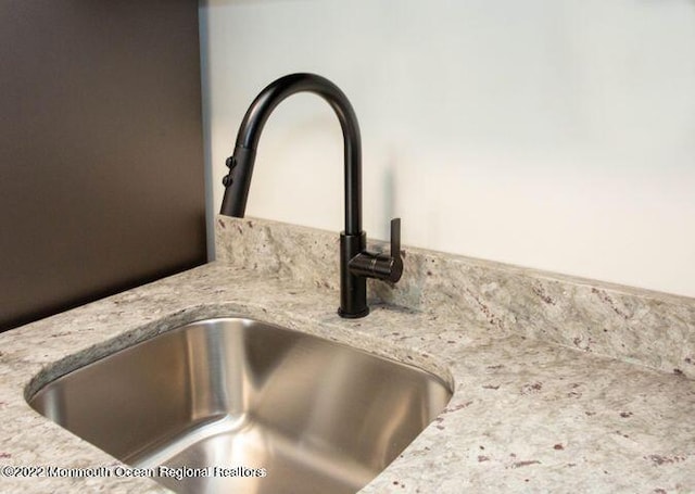 kitchen view of a sink and light stone countertops