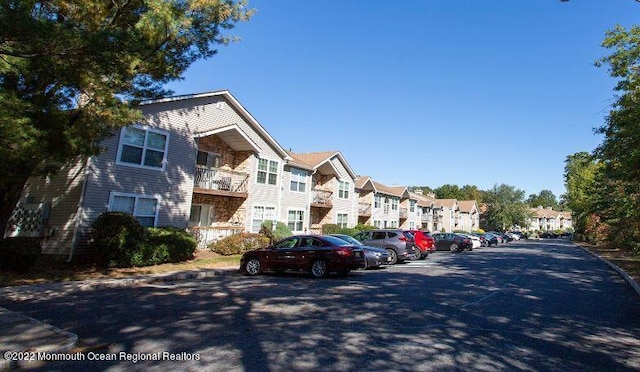 view of asphalt road with a residential view and curbs