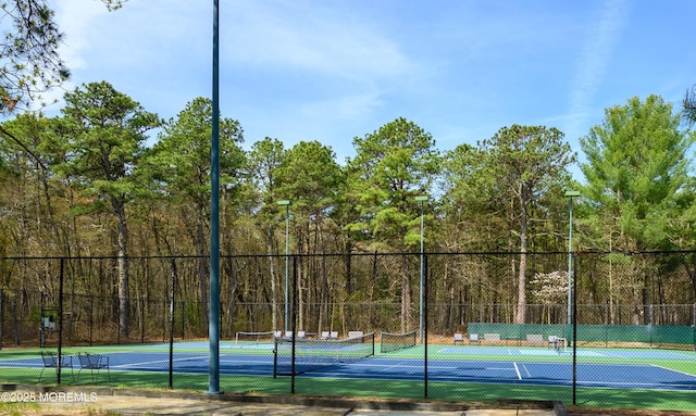 585 Waterford Dr, Manchester, NJ 08759 - view of tennis court featuring a forest view and fence