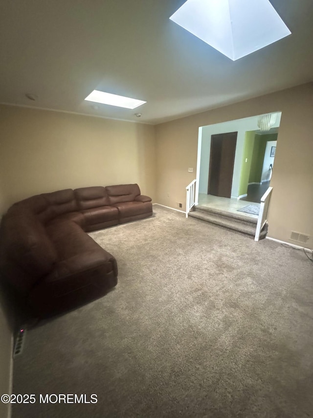 living room featuring a skylight, carpet floors, and baseboards
