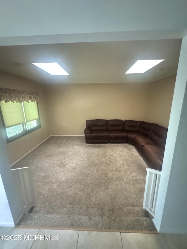unfurnished living room with carpet and a skylight