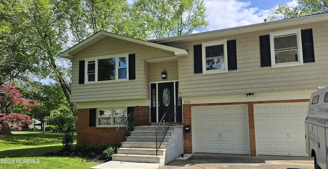 330 Broad St, Eatontown, NJ 07724 - bi-level home with a garage, brick siding, concrete driveway, and a front yard