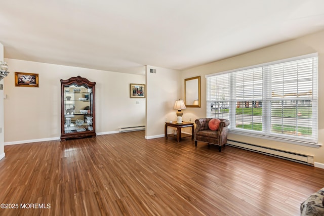 27 Gladstone Ave, Manchester, NJ 08759 - living area with baseboard heating, a baseboard heating unit, wood finished floors, and baseboards