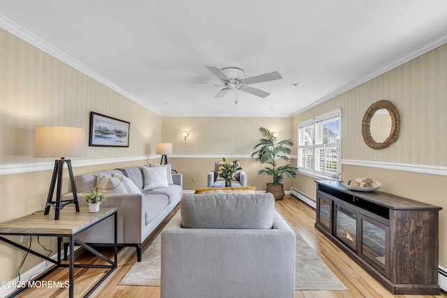 living room with baseboard heating, wood finished floors, crown molding, wallpapered walls, and ceiling fan