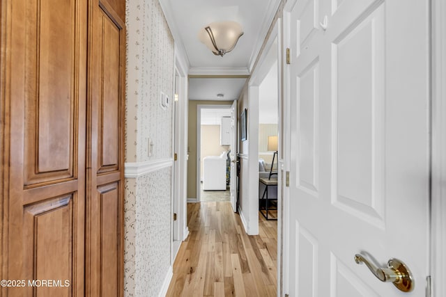corridor featuring wallpapered walls, light wood finished floors, and ornamental molding