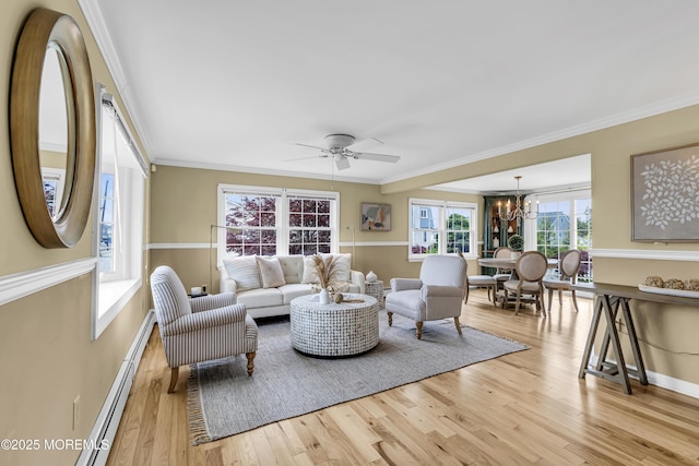 living room featuring a chandelier, wood finished floors, crown molding, baseboards, and a ceiling fan