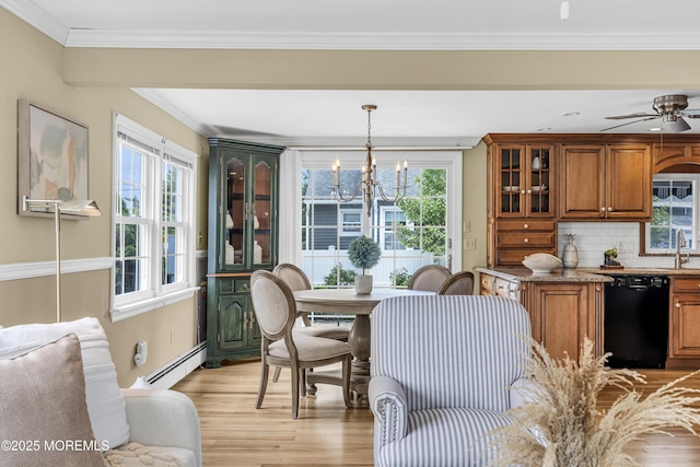 dining room with a baseboard radiator, a chandelier, light wood-style floors, plenty of natural light, and crown molding