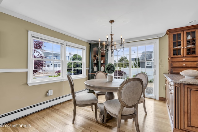 dining area with a baseboard heating unit, a chandelier, plenty of natural light, light wood finished floors, and crown molding