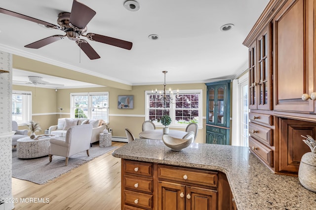 kitchen with a peninsula, light wood finished floors, a ceiling fan, brown cabinetry, and a baseboard heating unit