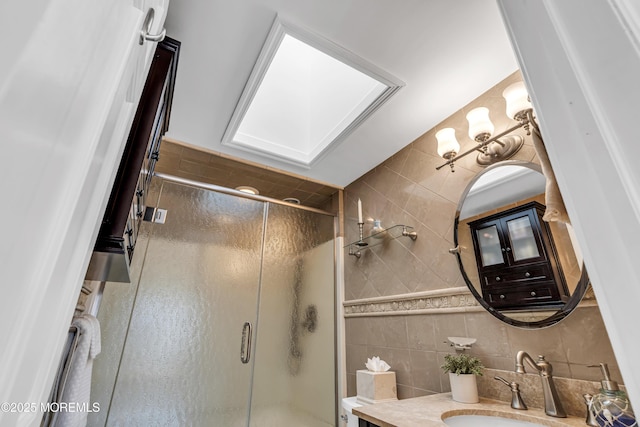 full bathroom with a shower stall, tile walls, vanity, and backsplash