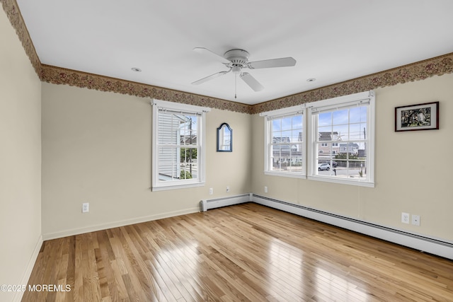 empty room with plenty of natural light, hardwood / wood-style floors, and a ceiling fan