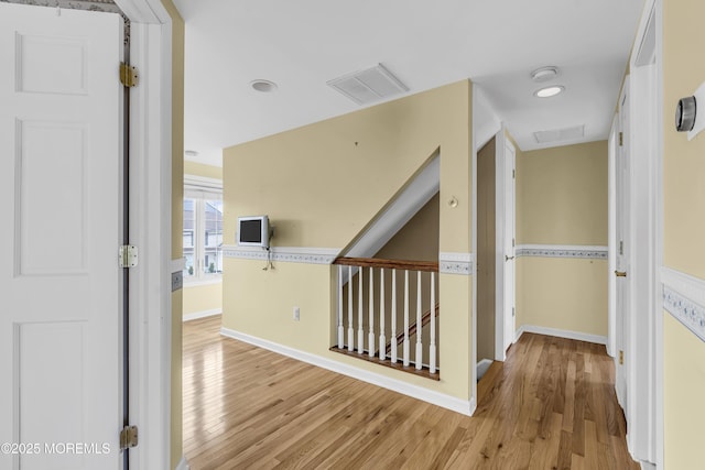 corridor with wood finished floors and baseboards