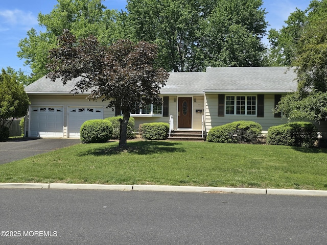 view of front facade with asphalt driveway, a front yard, a garage, and roof with shingles