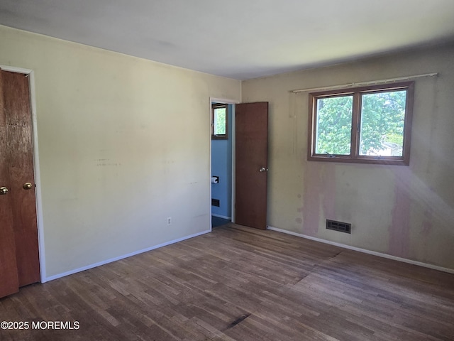 spare room with wood finished floors and baseboards