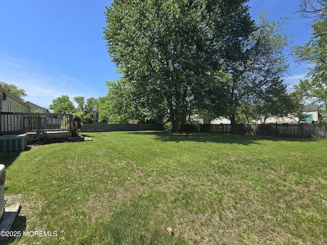 view of yard featuring a deck and central AC unit