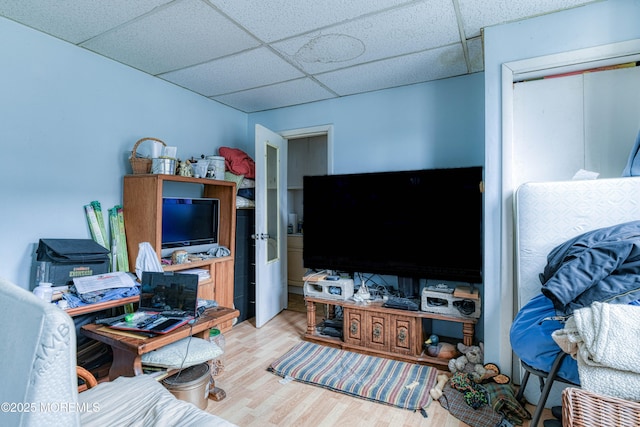 living area featuring a paneled ceiling and light wood finished floors