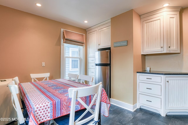 dining area with baseboards, dark stone finish floors, and recessed lighting
