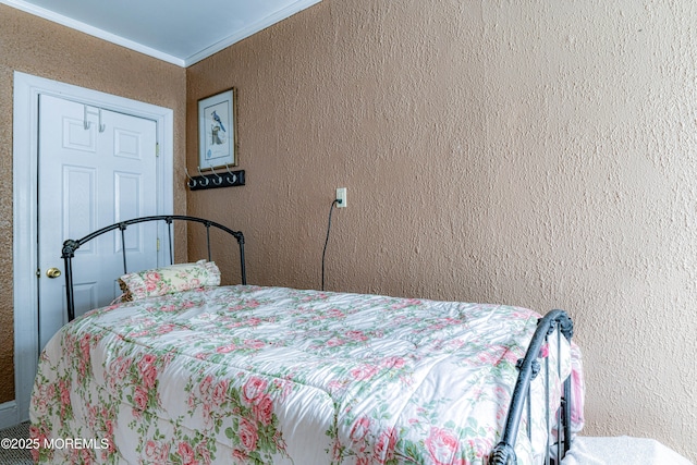 bedroom featuring a textured wall and crown molding
