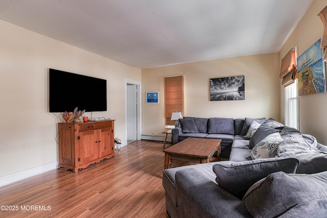 living area with wood finished floors, baseboards, and baseboard heating