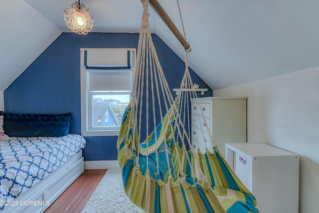 bedroom featuring vaulted ceiling, wood finished floors, and baseboards