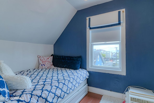 bedroom with lofted ceiling, wood finished floors, and baseboards