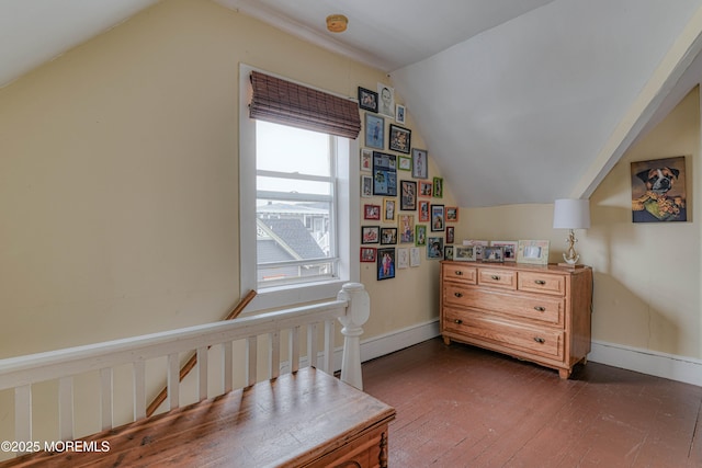 bedroom with vaulted ceiling, dark wood finished floors, and baseboards