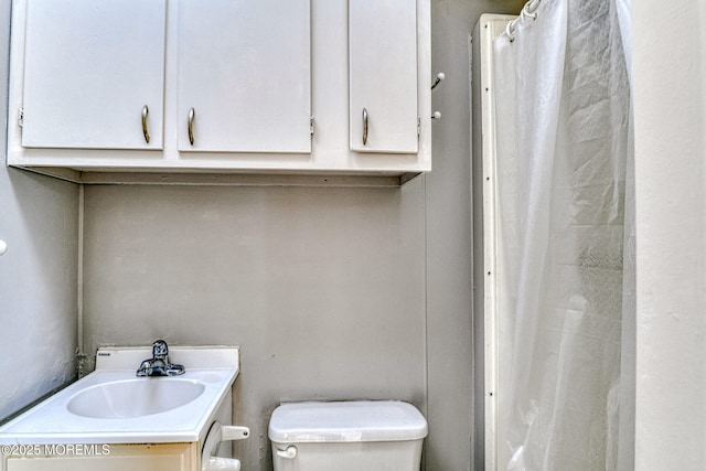 bathroom featuring toilet, vanity, and a shower with curtain