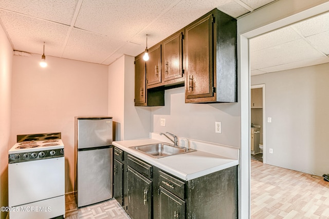 kitchen with electric range, a sink, a paneled ceiling, freestanding refrigerator, and light wood-style flooring