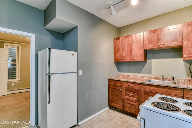kitchen with white appliances, a sink, a baseboard heating unit, rail lighting, and light countertops