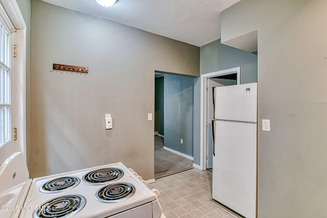 kitchen with white appliances, light flooring, and baseboards