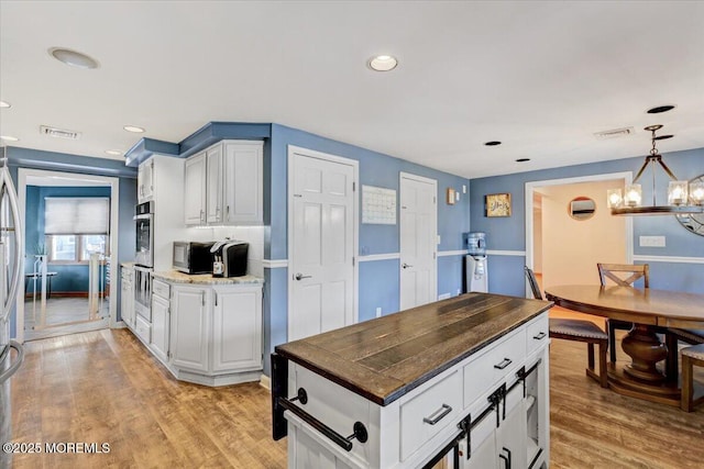 55 Yorktowne Dr, Manalapan, NJ 07726 - kitchen featuring a chandelier, white cabinetry, light wood-style floors, decorative light fixtures, and recessed lighting