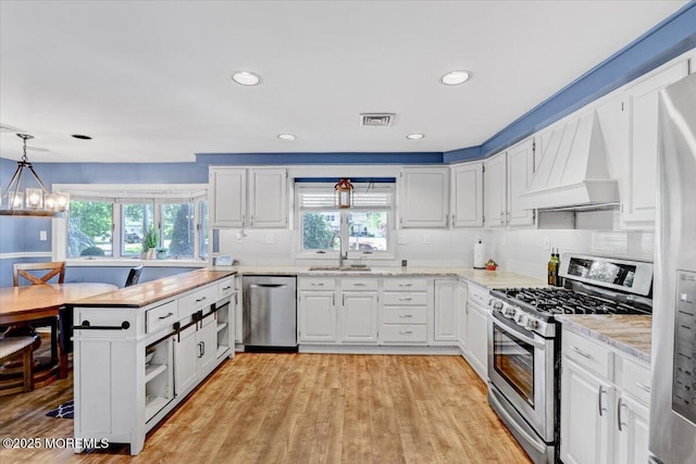 55 Yorktowne Dr, Manalapan, NJ 07726 - kitchen featuring stainless steel appliances, premium range hood, a sink, healthy amount of natural light, and recessed lighting