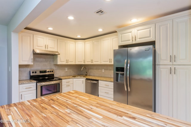 7 Danbury Ct, Red Bank, NJ 07701 - kitchen with appliances with stainless steel finishes, wooden counters, under cabinet range hood, tasteful backsplash, and recessed lighting