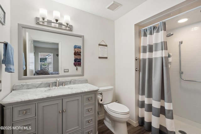 14 Winterton Dr, Toms River, NJ 08757 - ensuite bathroom with toilet, a tile shower, wood finished floors, vanity, and baseboards