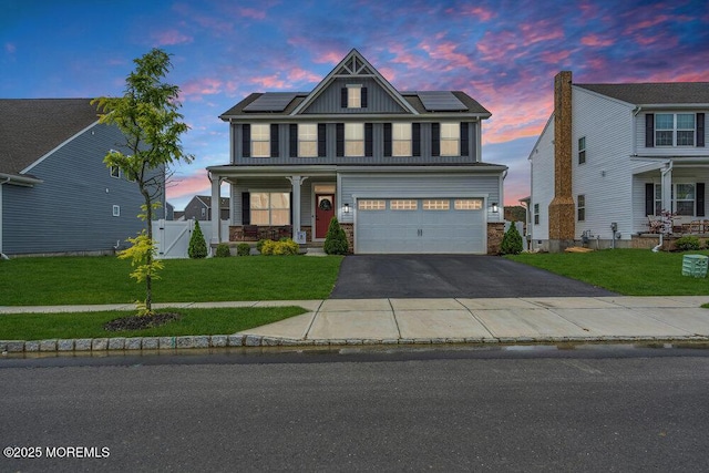 83 Weston Dr, Woolwich, NJ 08085 - view of front of house featuring driveway, a porch, a garage, roof mounted solar panels, and a gate