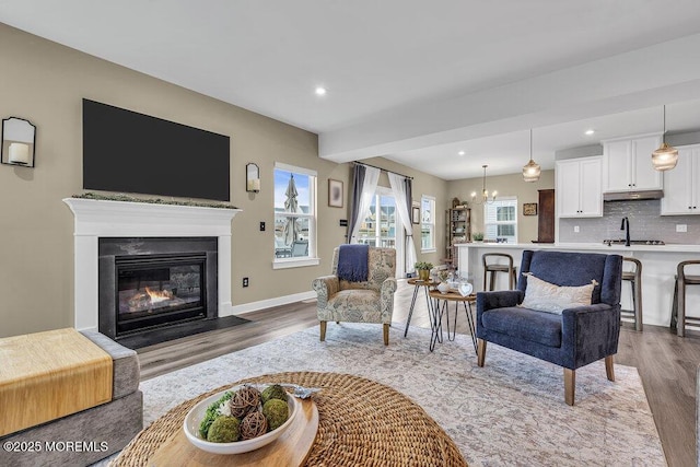 83 Weston Dr, Woolwich, NJ 08085 - living area featuring wood finished floors, a fireplace with flush hearth, recessed lighting, a chandelier, and baseboards