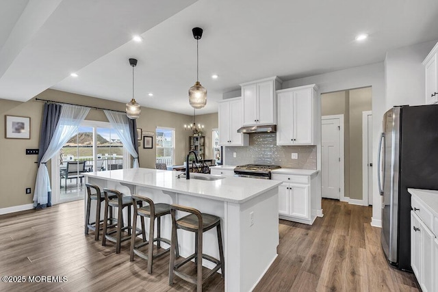 83 Weston Dr, Woolwich, NJ 08085 - kitchen with a sink, appliances with stainless steel finishes, under cabinet range hood, an island with sink, and baseboards
