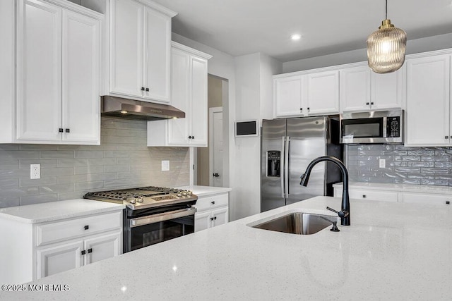 83 Weston Dr, Woolwich, NJ 08085 - kitchen with stainless steel appliances, under cabinet range hood, a sink, white cabinets, and light stone counters