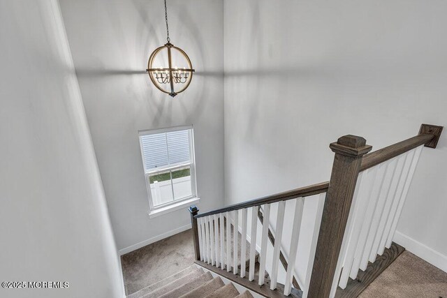 83 Weston Dr, Woolwich, NJ 08085 - stairs with a chandelier, baseboards, and carpet flooring