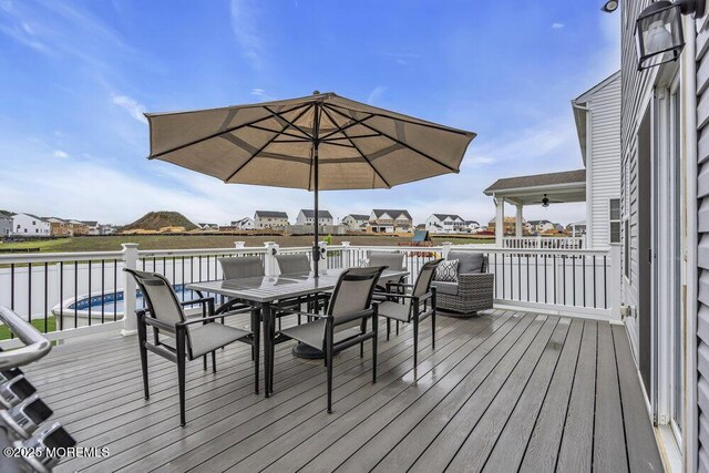 83 Weston Dr, Woolwich, NJ 08085 - deck with outdoor dining space, a ceiling fan, and a residential view