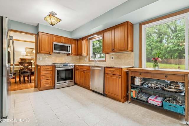 325 Oak Hill Rd, Red Bank, NJ 07701 - kitchen with stainless steel appliances, tasteful backsplash, brown cabinets, and light stone counters